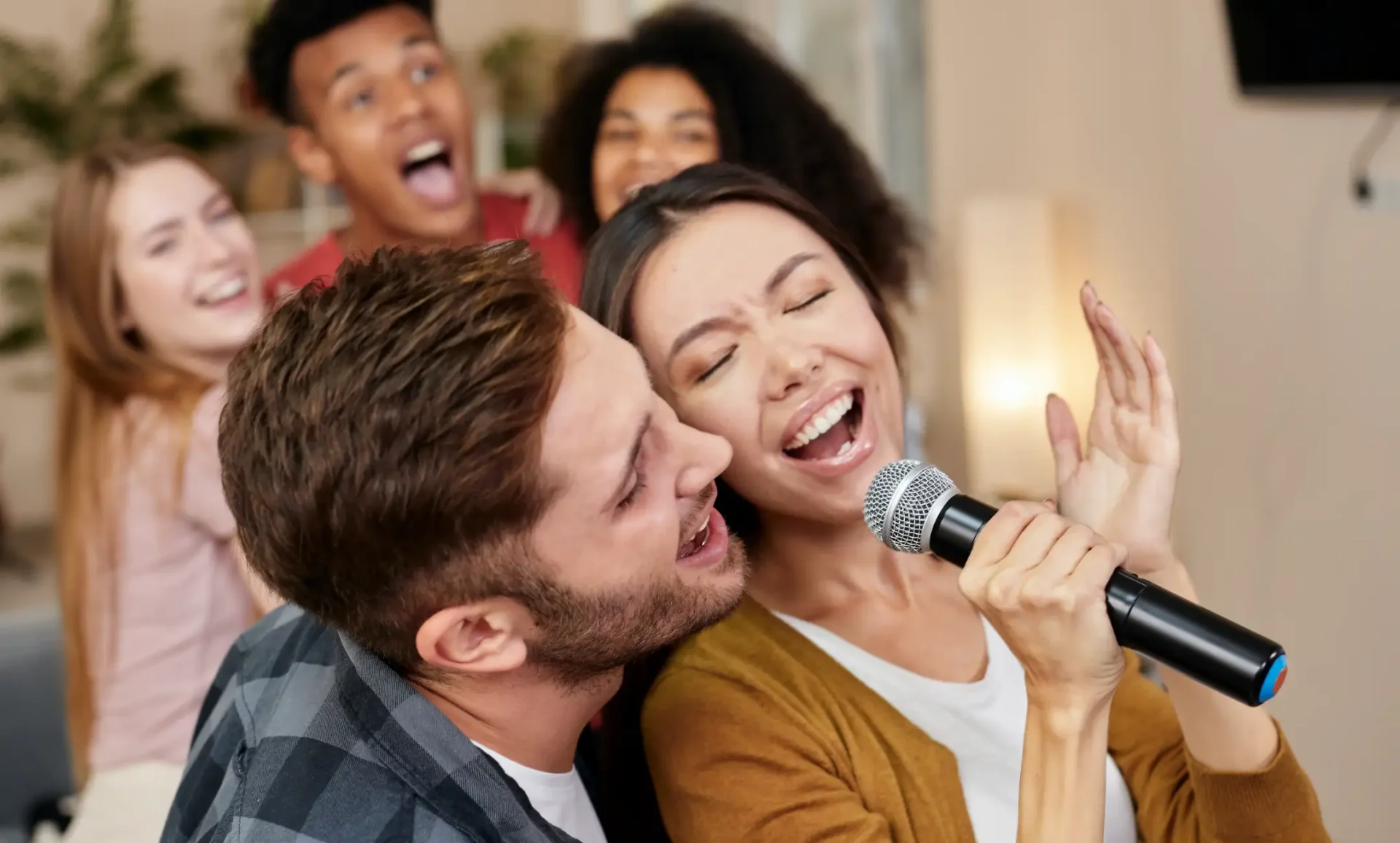 Sing Together. Young Couple Or Friends Holding Microphone And Singing Together Karaoke Night At The Kartrite